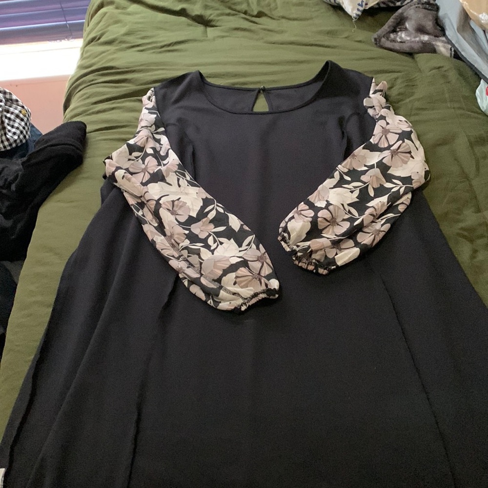 Black knee length dress with floral sleeves.
